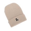 Close-up of beige ribbed knit beanie featuring thick cuff and black graphic logo detail - Off White