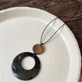 Détail macro du collier Zen avec texture en bois foncé et pendentif circulaire noir - Noir Marron (4#)