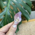 Macro shot of a purple iridescent mini shell hair clip with y2k dopamine style - Mini Conch / Pink Purple