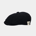 Detalle de gorra newsboy negra de algodón con etiqueta tejida blanca y textura del botón - Talla única / Negro