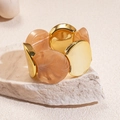 Dettaglio di bracciale elastico con dischi dorati e perline in resina marmorizzata - Marrone