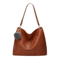Detailed shot of brown faux leather tote bag with grey pompom and gold hardware - Tan