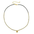 Macro detail of gold-plated hammered pendant on a minimalist beaded chain necklace - Retro Blue