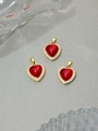 Primer plano de tres colgantes de corazón de resina roja con baño de oro y circonitas - Rojo