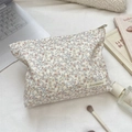 Macro detail of floral corduroy makeup bag with embroidery label and metal zipper - Pink Floral