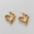 Detail van gouden hart oorbellen met lava-textuur en onregelmatig oppervlak in boho-stijl - Gouden oorbellen
