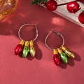 Macro detail of Christmas hoop earrings with colorful bulb pendants on a festive red background - D1296 (Colorful Light Bulbs)
