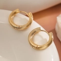 Minimalistische vergoldete gedrehte Creolen auf weißer Keramik präsentiert - Gold Verdreht Creolen