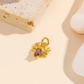 Détail d'un pendentif araignée doré avec une pierre violette taillée pour bijoux DIY - Violet