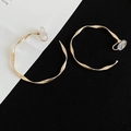 Macro shot of golden twisted wave textured C-shaped clip-on earrings on black and white surface - Clip-on Style / 5cm / Gold