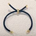 Detail of black Milan cord bracelet with adjustable gold-plated slider clasp and metal rings - Black