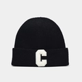 Detailed close-up of a black ribbed knit beanie featuring a white plush letter C patch - Black