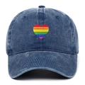 Gros plan détaillé d'un cœur arc-en-ciel brodé sur une casquette en denim délavé - Bleu marine