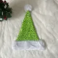 Detail einer funkelnden grünen Pailletten-Weihnachtsmütze mit weißem Plüschrand und Bommel - 31*47cm / Fruchtgrün