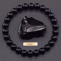 Natural black onyx beaded bracelet featuring a raw irregular stone centerpiece on grey background - Obsidian