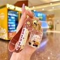 Detail of bear milk tea keychain with pink bear in fluid bottle and brown silicone strap - Milk Tea Bear Barrel