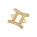 Macro shot of gold Gemini zodiac pendant featuring white cubic zirconia connectors - Gold Gemini