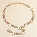 Detail of gold metal waist chain belt with embossed rings and adjustable lobster clasp - Gold