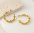 Detalle macro de pendientes de aro geométricos retorcidos bañados en oro de 18 quilates - E169 Pendientes de Resorte Forma C Bambú Dorado