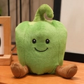 Niedliches grünes Paprika Kuscheltier mit lachendem Gesicht und Beinen auf dem Tisch - Grüne Paprika / Grün