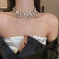 Detail einer silbernen Quastenkette mit Strasssteinen, getragen von einem Model - Silberne Halskette mit Großen Quadratischen Strass-Quasten