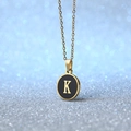 Golden round pendant necklace with black enamel inlay featuring a capital letter K - Letter K