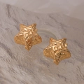 Lustrous gold star-shaped earrings with irregular textured finish on marble background - Gold Star Style (45051)