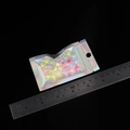 Holographic PET zip lock bag with colorful star beads shown beside a metal ruler - Micro