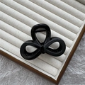 Glossy black triple-loop bow hair claw clip in a velvet jewelry tray on marble surface - 8cm Figure 8 / Bright Black