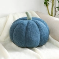 Primer plano de un cojín de calabaza azul oscuro en suave vellón sobre manta blanca - Azul