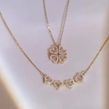 Detailed view of foldable magnetic four-leaf clover necklace with sparkling heart charms - Double-wear Clover Necklace / Gold