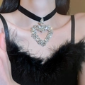 Black velvet choker necklace with large shimmering crystal heart pendant on female model - Rhinestone Heart Velvet Choker Necklace