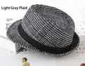 Détail d'un chapeau fedora gris à carreaux avec ruban noir sur un décor de livres anciens - Taille Unique 58cm / Gris à Carreaux