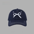 Close-up of white bow embroidery detail on a dark blue denim baseball cap - Denim Bow Baseball Cap Style / Navy Blue