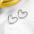 Polished silver hollow heart stud earrings on a natural white stone display tray - Hollow Heart Studs / Steel Color Earrings