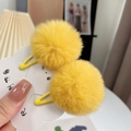Detail of yellow faux fur pom pom hair clips on a white cloud-shaped display card - One Pair / Orange Yellow