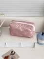 Pink bow-quilted cosmetic bag with white zipper on a white tiered display stand - Without Charm / Pink