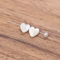 Detail view of double white heart pins with gold H letter and a round pearl accent - Letter H
