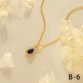 Close-up of heart-shaped gold necklace with blue gemstone and white zircon stones - Sodalite