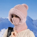 Cappuccio in maglia rosa con bordo in ecopelliccia e pompon indossato davanti a cime innevate - Rosa