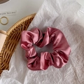 Detail of dusty pink satin scrunchie with soft pleats and elegant glossy finish - Grapefruit Red