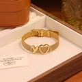 Détail d'un bracelet doré avec lettre Y et cœur dans un coffret cadeau en bois - Lettre Y