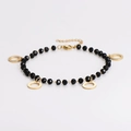 Détail d'un bracelet de perles en verre noir facettées et de pendentifs ronds dorés - Bracelet / Noir/Or