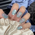 Macro detail of light blue press-on nails with pink floral motifs and pearl accents - By1535 Crystal Pink Peach Blossom / Glue Type
