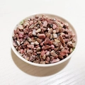 Pink and black natural crystal stones for DIY decoration in a white ceramic bowl - Rhodonite