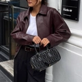 Women's burgundy faux leather jacket styled with a black quilted handbag for autumn - S / Dark Red