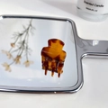Mini acetate hair claw clip in tortoiseshell pattern displayed on a vanity mirror - Coffee Square