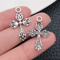 Ciondoli a croce vintage in argento per gioielli fai-da-te mostrati in mano - Croce Fantasia-16x25mm