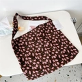 Detailed macro view of a brown corduroy tote bag with pink floral patterns and a tag - Kerria Brown