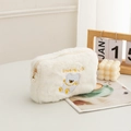 Close-up of white plush cosmetic bag with bear embroidery and elegant pearl zipper pull - White Bear